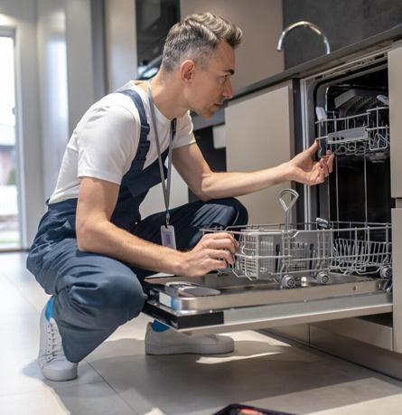 Technician inspecting a dishwasher during a repair visit in Bangalore